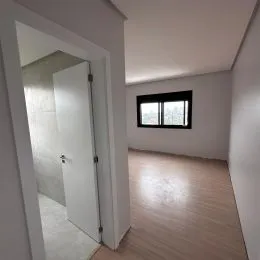 Hall de entrada com piso de madeira clara.