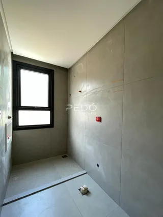 Corredor interno com parede lisa e janela.