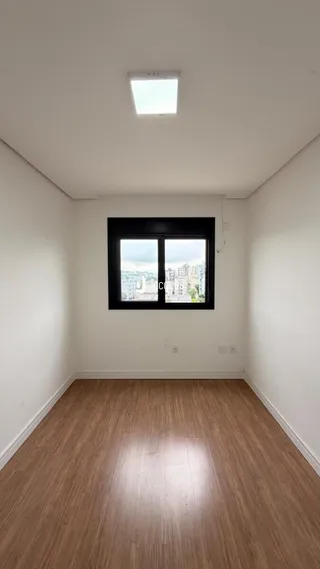 Foto de uma sala com piso de madeira e janela.