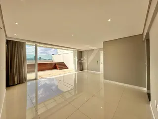 Sala de estar ampla com piso de cerâmica clara e portas de vidro que dão acesso ao exterior.