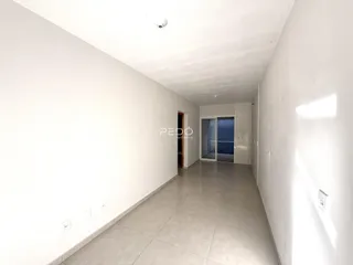 Corredor interno de uma residência com paredes brancas e piso de cerâmica clara.
