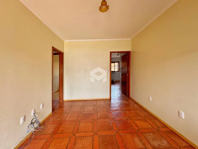 Corredor interno com piso de cerâmica avermelhada.