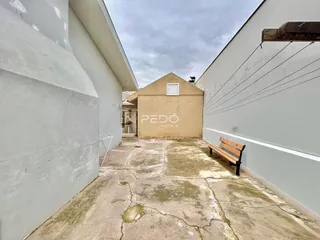 Vista externa de um pátio entre duas paredes brancas em Lajeado.