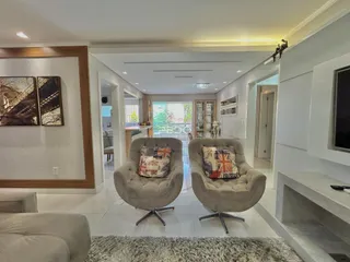 Sala de estar com duas poltronas em um ambiente claro.