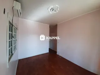 Sala de estar com piso de madeira e ar-condicionado visível.