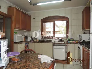 Foto interna de uma cozinha com armários de madeira e bancadas.