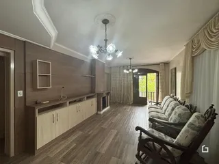 Sala de estar com piso de madeira e sofá em um imóvel no Brasil.