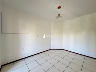 Imagem de um ambiente interno com paredes brancas e piso de cerâmica.