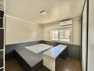Quarto com cama e bancada de trabalho em ambiente moderno.