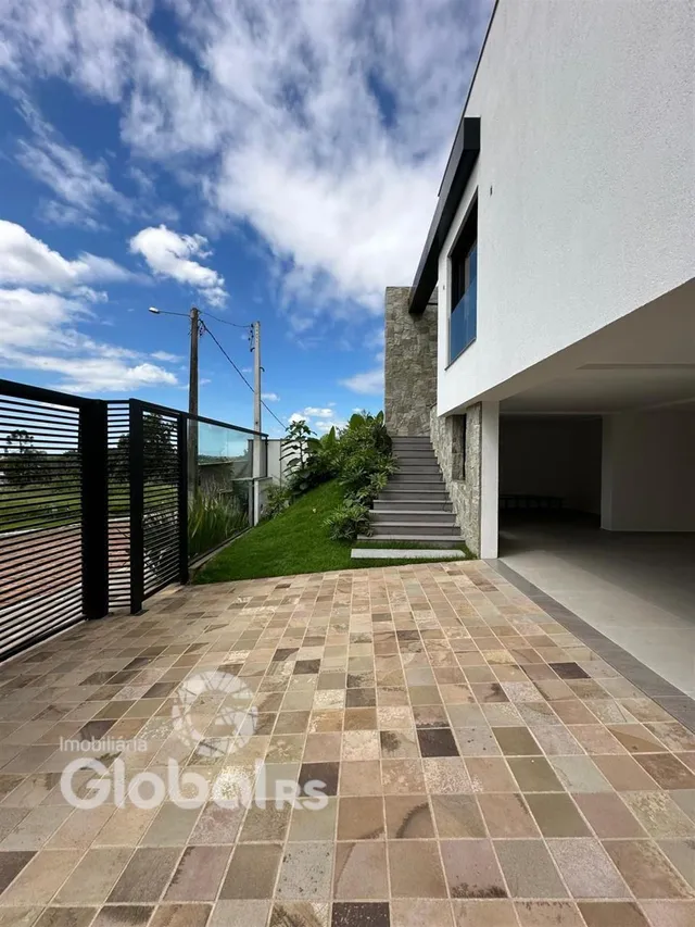Vista da fachada e área externa pavimentada de uma residência em Lajeado.