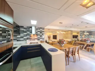Vista da cozinha moderna com armários azuis e bancadas claras.