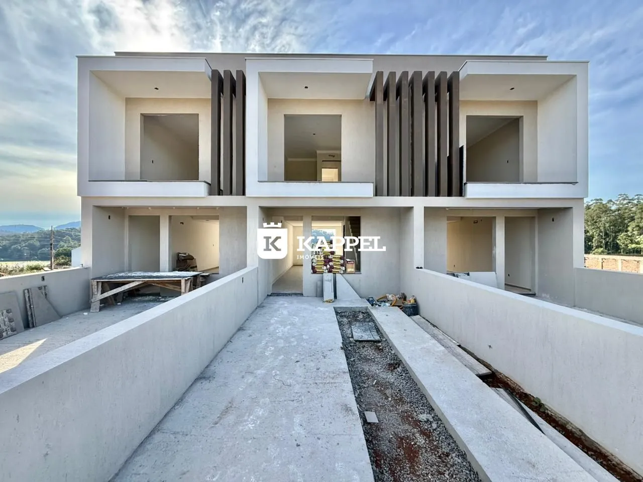 Fachada moderna de uma casa de dois andares com terraço e vista para a paisagem.