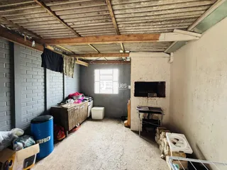 Foto de um ambiente interno com teto de madeira exposto e parede de tijolos.