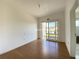 Interior de uma sala com piso de madeira e porta de vidro.