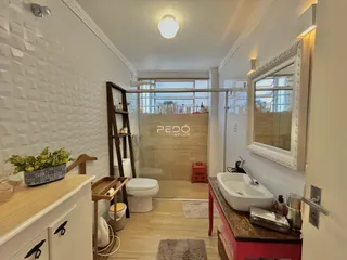 Hall de entrada com parede texturizada e piso de madeira clara.