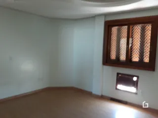 Ambiente interno com piso de madeira e janela na parede.