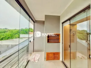Foto de um hall com escada e vista externa através de grandes painéis de vidro.