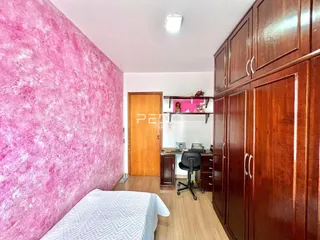 Quarto com paredes rosa vibrantes e armários de madeira escura.