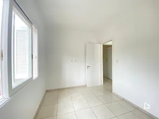 Hall de entrada com piso de cerâmica e paredes brancas em um imóvel no Brasil.