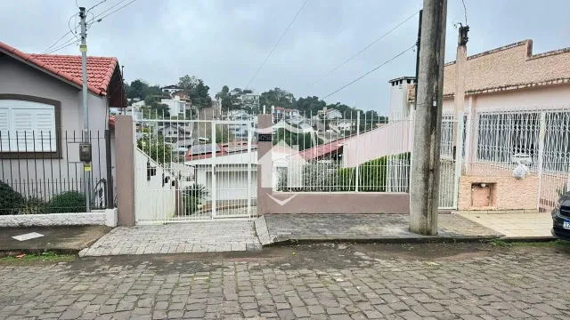 A fachada de uma residência em Lajeado, Brasil, com cerca e portão de ferro.