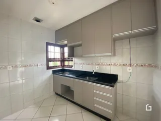 Vista da cozinha com armários superiores e revestimento cerâmico.