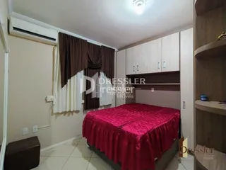 Quarto com cama e painéis de madeira na sala.