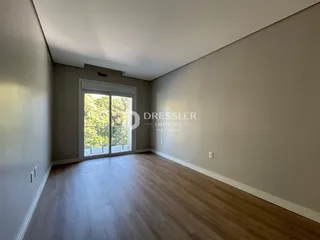 Uma sala de estar com piso de madeira e porta de vidro que dá para o exterior.