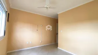Interior de um corredor com paredes em tom bege claro e piso de cerâmica.