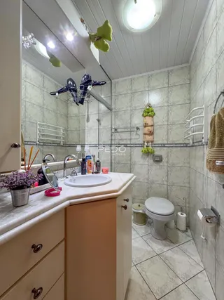 Foto de um banheiro com revestimento cerâmico e bancada de mármore.