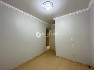 Hall de entrada com piso de madeira clara e paredes brancas.