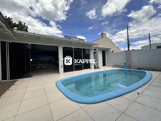 Foto da área externa com piscina e porta de vidro em uma residência.