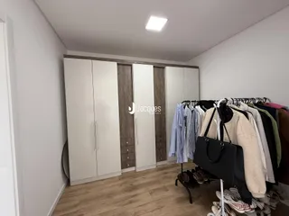 Quarto com armário embutido e piso de madeira clara.
