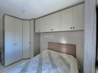 Quarto com armários embutidos e cama em um imóvel no Brasil.