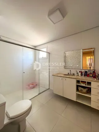 Foto de um banheiro com piso de cerâmica e box de vidro.