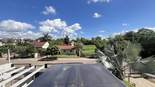Vista externa de uma propriedade com vegetação e céu azul.