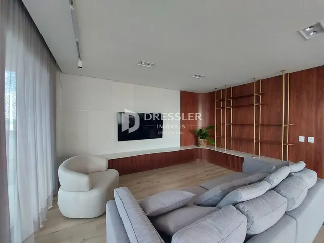 Sala de estar moderna com sofá e poltrona em madeira clara.