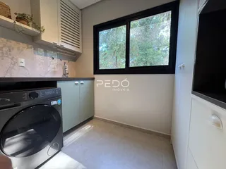 Foto de uma cozinha com armários e máquina de lavar roupa em um imóvel.