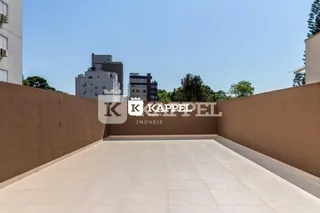Vista de um pátio externo pavimentado com paredes altas.
