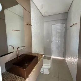 Foto de um banheiro interno com bancada e vaso sanitário.