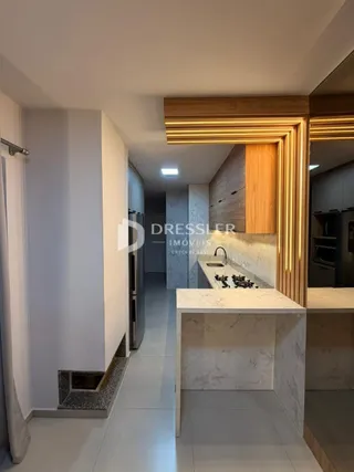 Interior de uma cozinha moderna com armários de madeira e bancada clara.