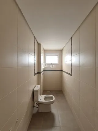 Corredor interno com paredes brancas e piso de cerâmica.