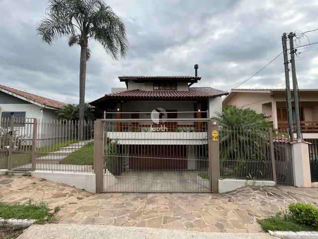 Fachada de uma residência com portão de ferro e cerca em Lajeado, Brasil.