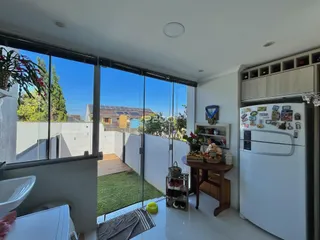 Sala de estar com portas de vidro que dão acesso ao jardim externo.