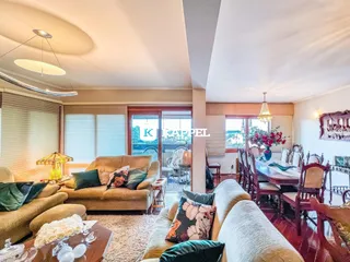Sala de estar com sofá e mesa de centro, com vista para o exterior.
