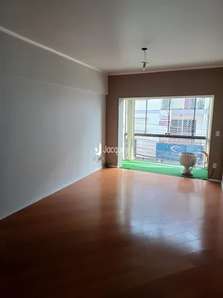 Sala de estar com piso de madeira e vista para o jardim externo.