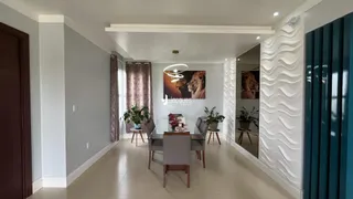 Interior de uma sala de jantar com paredes cinzas e piso claro.
