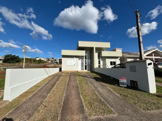 Fachada de uma casa moderna em Lajeado, Brasil, com muro branco e entrada pavimentada.