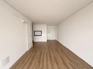 Hall de entrada com piso de madeira clara.