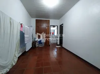 Interior de uma sala com piso de cerâmica e portas de madeira.