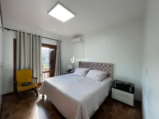 Quarto com piso de madeira e janela em imóvel no Brasil.